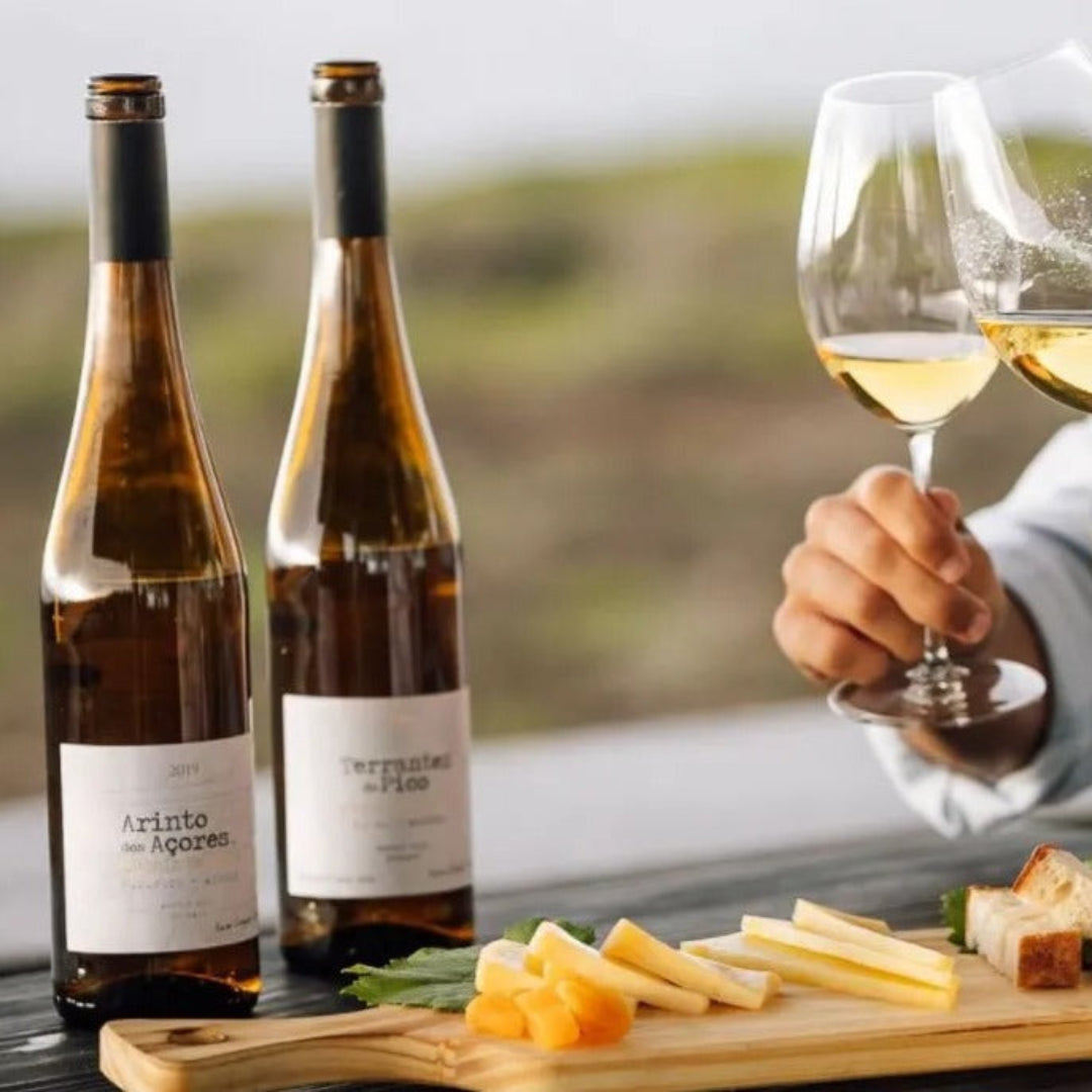 Zwei Flaschen mit Azoren Wein vor Käsebrett